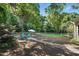 Secluded backyard with mature trees, a patio with a fire pit, and fenced area at 3005 Piney Grove Wilbon Rd, Holly Springs, NC 27540