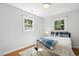 Bedroom features hardwood flooring, a double bed with blue accents, and natural lighting at 3005 Piney Grove Wilbon Rd, Holly Springs, NC 27540