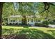 Charming one-story home featuring a brick chimney, light shutters, and a well-maintained lawn with mature trees at 3005 Piney Grove Wilbon Rd, Holly Springs, NC 27540