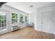 Bright sun room with hardwood flooring, large windows and a cozy chair at 3005 Piney Grove Wilbon Rd, Holly Springs, NC 27540