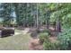 Landscaped backyard with mature trees, grassy areas, and patio space for relaxing at 3058 Hyco Lake Ct, Fuquay Varina, NC 27526