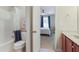Bathroom with a shower, toilet, and a view of a bedroom with blue curtains through a doorway at 3058 Hyco Lake Ct, Fuquay Varina, NC 27526