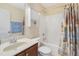Bathroom with a single sink vanity, toilet, and shower-tub combination with a shower curtain and towel racks at 3058 Hyco Lake Ct, Fuquay Varina, NC 27526