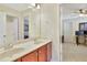 Bathroom with double sinks, wood cabinets, and a view through a doorway to a bedroom and another bathroom at 3058 Hyco Lake Ct, Fuquay Varina, NC 27526
