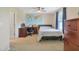Bedroom featuring a desk, a bed, a world map, and a wooden dresser, illuminated by a ceiling fan and natural light at 3058 Hyco Lake Ct, Fuquay Varina, NC 27526