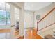 Welcoming foyer featuring hardwood floors, a staircase, and a view into a bright office space at 3058 Hyco Lake Ct, Fuquay Varina, NC 27526