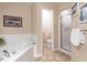 Relaxing bathroom showcasing a soaking tub, separate shower, and tiled floor for spa-like comfort at 3652 E Cotton Gin Dr, Clayton, NC 27527