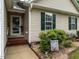 Close up of entrance with a Welcome sign, green shutters and brick accents and tidy landscaping at 3652 E Cotton Gin Dr, Clayton, NC 27527