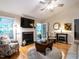 Inviting living room featuring a fireplace, hardwood floors, and comfortable seating arrangement under a ceiling fan at 3652 E Cotton Gin Dr, Clayton, NC 27527