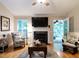 Bright living room showcasing a fireplace, stylish seating, and an open doorway to another sunlit space at 3652 E Cotton Gin Dr, Clayton, NC 27527