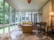 Bright sun room with leafy rug, great views of outdoor greenery, and comfortable seating for relaxation at 3652 E Cotton Gin Dr, Clayton, NC 27527