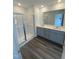Bathroom featuring dual sinks, a vanity with gray cabinetry, and a glass-enclosed shower at 369 Thompson Overlook Way, Smithfield, NC 27577