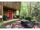 Inviting front porch with a cozy seating area and a red door, perfect for relaxing outdoors at 3822 Chicken Bridge Rd, Pittsboro, NC 27312