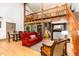 Inviting living room featuring a vaulted ceiling, exposed beams, fireplace, and open staircase leading to a loft area at 3822 Chicken Bridge Rd, Pittsboro, NC 27312