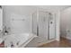 Bright bathroom with a corner soaking tub and glass-enclosed shower, blending style and functionality at 3921 Robins Nest Ln, Wake Forest, NC 27587