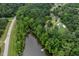 Aerial view of a lake surrounded by lush greenery, with a dock at 394 Flanagan Rd, Henderson, NC 27537