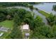 Aerial view of home nestled in trees with a waterfront view and bridge at 394 Flanagan Rd, Henderson, NC 27537