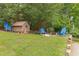 Backyard with wooded area and fire pit including blue outdoor chairs at 394 Flanagan Rd, Henderson, NC 27537