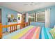 Bright bedroom with colorful bedding, a ceiling fan, and multiple windows at 394 Flanagan Rd, Henderson, NC 27537