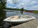 Pleasant view of a parked boat by a weathered dock near a bridge, and calm water, under a partly cloudy blue sky at 394 Flanagan Rd, Henderson, NC 27537