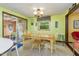 Cozy dining area with a wooden table, four chairs, bright green walls, and access to an outdoor deck at 394 Flanagan Rd, Henderson, NC 27537