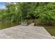 Large wooden dock with hot tub and wooden stairs leading to a lush green forest at 394 Flanagan Rd, Henderson, NC 27537