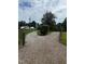 Gravel driveway leading up to a property entrance flanked by lush greenery at 394 Flanagan Rd, Henderson, NC 27537