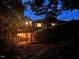Dusk exterior view of home with wood siding, deck, and string lights underneath at 394 Flanagan Rd, Henderson, NC 27537