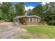 Charming exterior of home with a covered porch, well-maintained lawn, and beautiful landscaping at 394 Flanagan Rd, Henderson, NC 27537