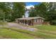 Charming single-story home featuring a cozy front porch and beautiful mature trees at 394 Flanagan Rd, Henderson, NC 27537
