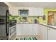 Functional kitchen featuring white cabinetry, stainless steel appliances, and bright green walls at 394 Flanagan Rd, Henderson, NC 27537