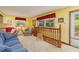 Comfortable living room with a plush blue sofa, large windows, and wooden railing, creating a warm, inviting space at 394 Flanagan Rd, Henderson, NC 27537
