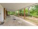 Long covered porch with a table and chairs. Perfect for enjoying peaceful views of surrounding greenery at 394 Flanagan Rd, Henderson, NC 27537