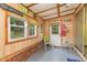Bright, enclosed porch features wood panels and windows providing natural light and views of the yard at 394 Flanagan Rd, Henderson, NC 27537