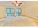 Spacious bedroom with neutral carpet, ceiling fan, and sliding glass doors to private balcony at 406 Fairoaks Cir, Chapel Hill, NC 27516