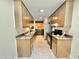 Galley kitchen features tiled floors, stainless steel appliances and cabinetry on both sides with contrasting countertops at 406 Fairoaks Cir, Chapel Hill, NC 27516