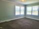 Well-lit bedroom with neutral carpet, baseboard, and two windows providing ample light at 411 W Raleigh St, Siler City, NC 27344