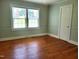 Bright bedroom featuring hardwood floors, neutral paint, and two windows providing ample natural light at 411 W Raleigh St, Siler City, NC 27344