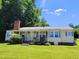 Charming single-story home with a brick chimney, inviting front porch, and well-maintained lawn at 411 W Raleigh St, Siler City, NC 27344