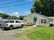 A well-maintained single story house that has a clean yard with a gravel parking area at 411 W Raleigh St, Siler City, NC 27344
