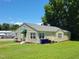 Well-maintained home exterior featuring a covered side entrance, tidy landscaping, and a green lawn at 411 W Raleigh St, Siler City, NC 27344