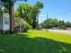 A lush green lawn and partial view of a charming house, complemented by trees and a blue sky at 411 W Raleigh St, Siler City, NC 27344