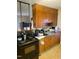 Traditional kitchen featuring wood cabinetry, black appliances, and laminate flooring at 411 W Raleigh St, Siler City, NC 27344