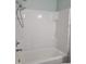 White tiled shower and tub in the bathroom is clean and bright at 411 W Raleigh St, Siler City, NC 27344
