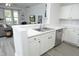 Kitchen with white cabinets and stainless steel appliances overlooks the living room with gray floors at 4224 Vienna Crest Drive Dr, Raleigh, NC 27613