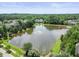 Scenic aerial view of a community pond with a fountain, surrounded by lush trees and homes at 4229 Cats Paw Ct, Wake Forest, NC 27587