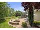 Idyllic backyard showcasing a fire pit, outdoor cooking area and lush greenery and trees at 4229 Cats Paw Ct, Wake Forest, NC 27587