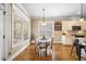 Sunlit breakfast nook with hardwood floors and views to the backyard through large windows at 4229 Cats Paw Ct, Wake Forest, NC 27587