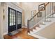 Open foyer with hardwood floors, a staircase and black framed glass panel door at 4229 Cats Paw Ct, Wake Forest, NC 27587