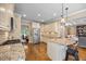 Open kitchen with granite countertops, stainless appliances, white cabinets and hardwood floors at 4229 Cats Paw Ct, Wake Forest, NC 27587